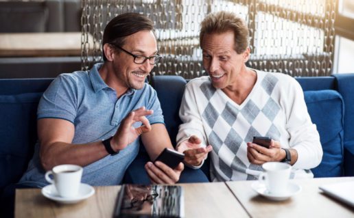 Dos hombres felices mirando los teléfonos