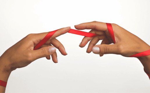 Two hands wrapped in red ribbon, touching, representing HIV testing in Indianapolis