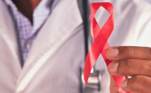 Doctor holding up a red ribbon for HIV awareness